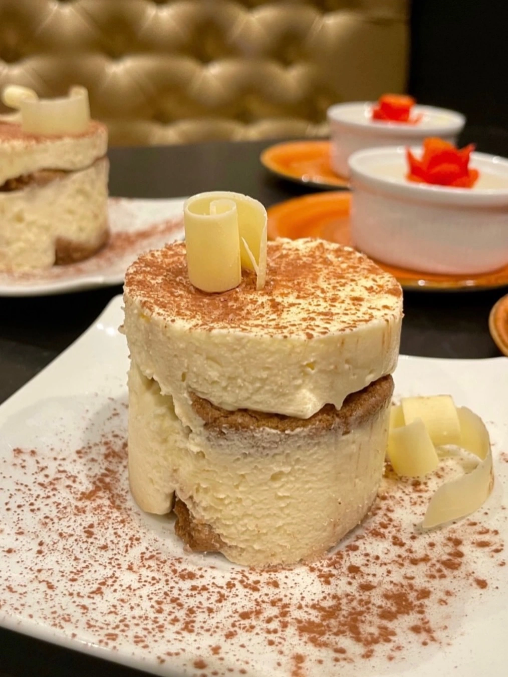 Mini tiramisu cake topped with white chocolate curls and cocoa powder