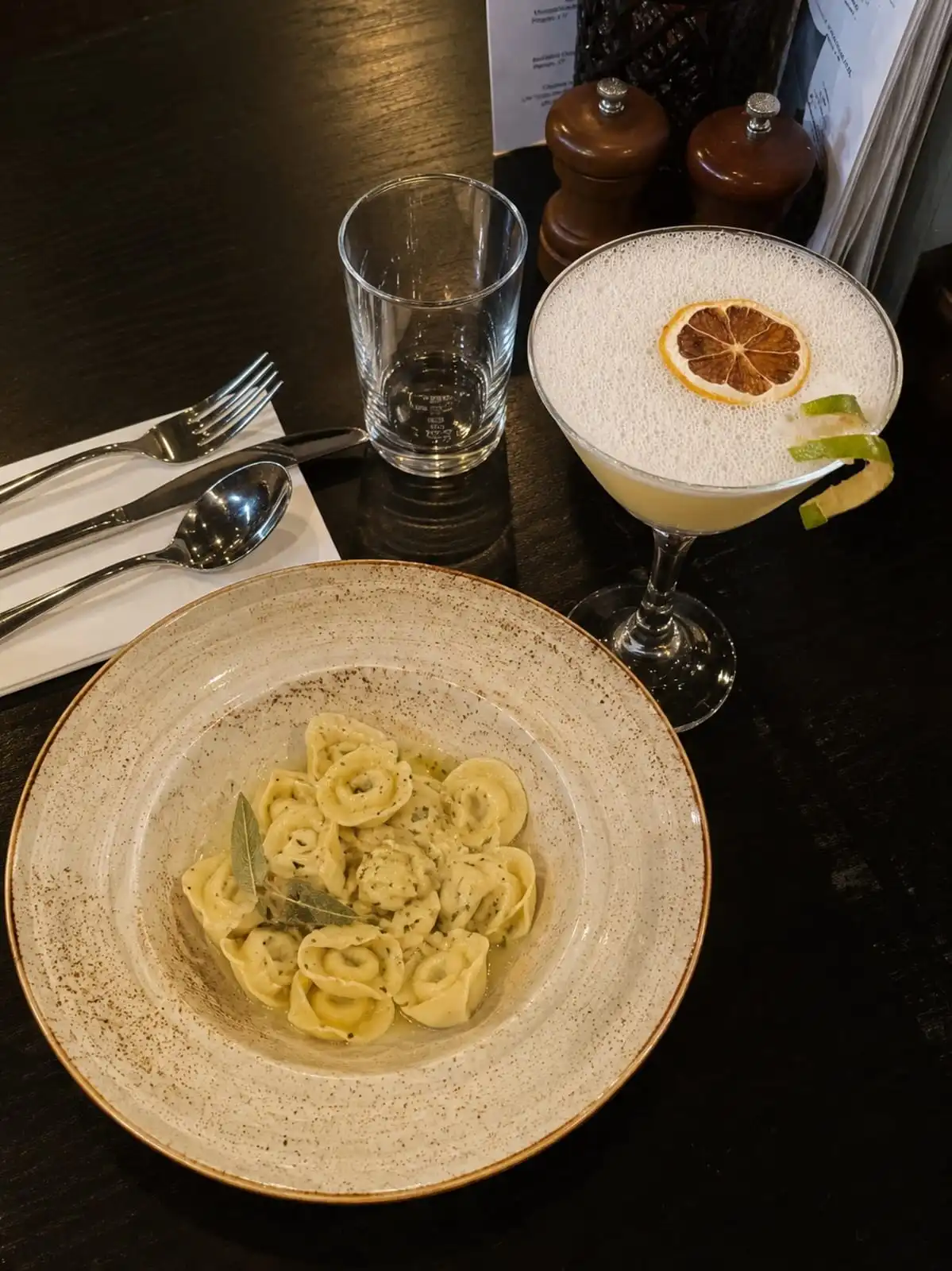 Tortellini pasta dish served with a cocktail